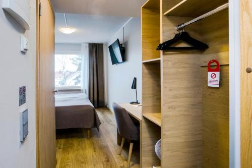 a small room with a bed and a desk at Hotelli Toivola in Kemi