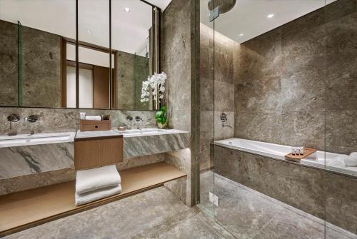 a bathroom with a tub and a sink at Pan Pacific Jakarta in Jakarta