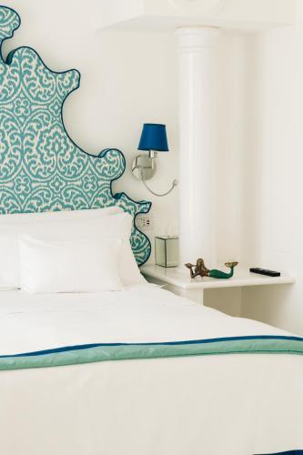 a bedroom with a bed with a blue and white headboard at Villa Boheme Exclusive Luxury Suites in Positano