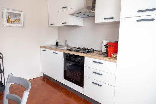 a kitchen with white cabinets and a black stove top oven at Savian Apartment in Savigliano