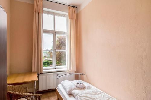 a room with a bed in front of a window at Herrenhaus Marienhof in Krakow am See
