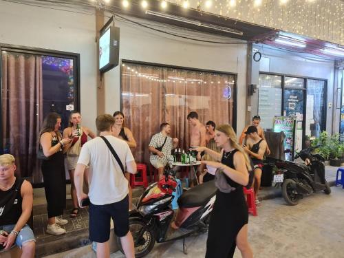 a group of people standing in a room with motorcycles at The Rendezvous Fullmoon Hostel in Haad Rin