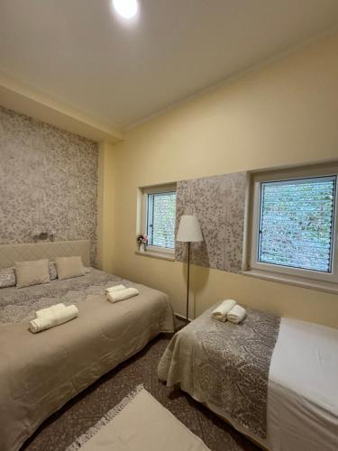 a bedroom with two beds and a lamp and two windows at Apartment OLIVA1 in Petrovac na Moru