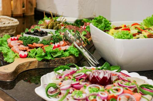 a table topped with plates of salad and vegetables at Afrodyta Spa in Świnoujście