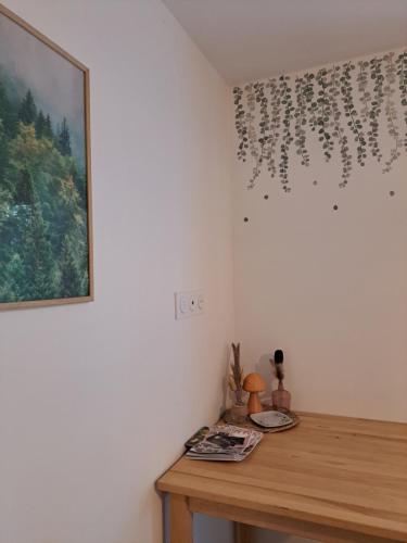 een tafel in een kamer met een schilderij aan de muur bij Chambre indépendante en forêt in Plessé