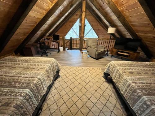 a attic bedroom with two beds and a living room at Sage Hill Cabin in Londonderry