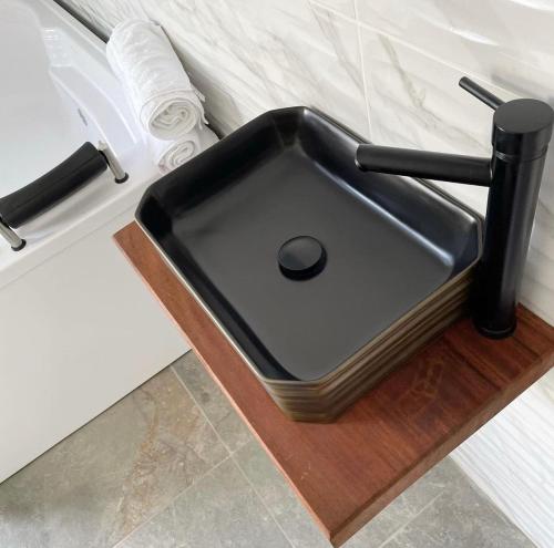 a black sink on a wooden counter in a bathroom at Eco Hotel Montenegro in Medellín