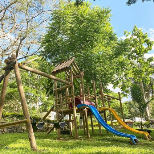 a playground with a slide in a park at Eco Hotel Montenegro in Medellín