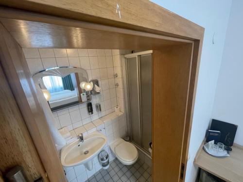 bagno con lavandino, servizi igienici e specchio di Hafner Hotel- Apartment a Stoccarda