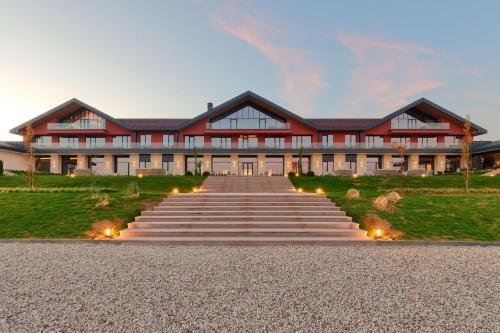 un gran edificio rojo con escaleras que conducen a él en Katarzyna estate - L'Ambassade de Katarzyna en Svilengrad