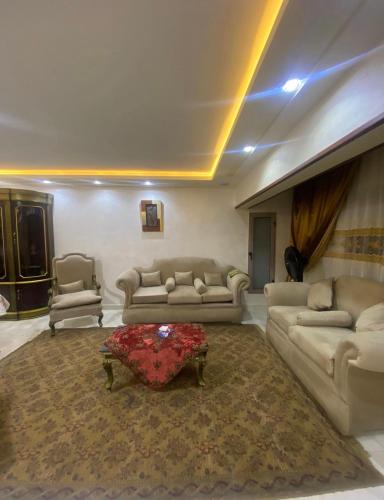 a living room with couches and a coffee table in it at شقة فندقية مميزة بالمنصورة in Ṭalkha
