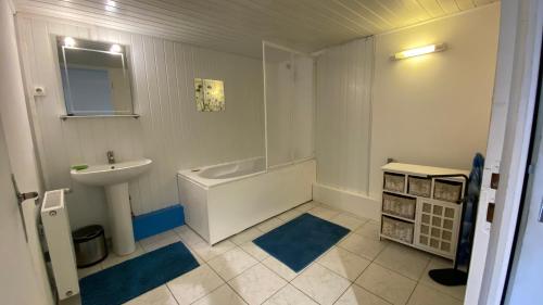 een badkamer met een bad, een wastafel en een toilet bij Les Landes avec Terrasse et Jardin in Heuringhem