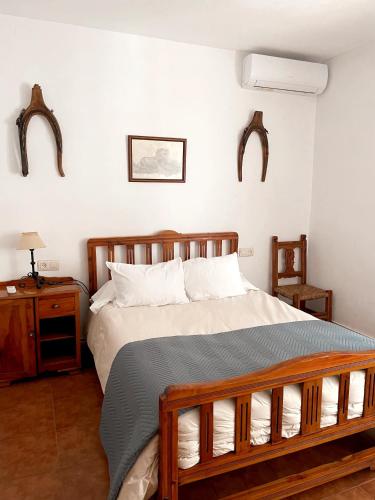 a bedroom with a large bed and a night stand at Casa Rural Pernales I in Ruidera