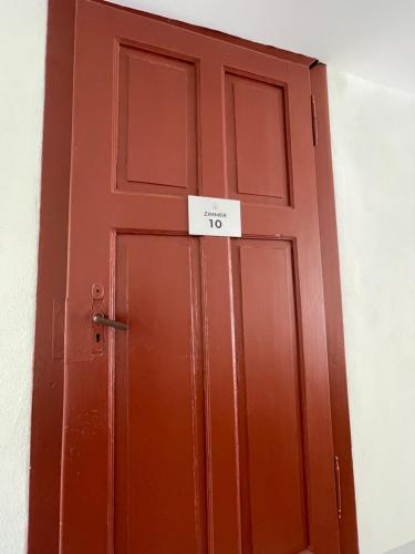 a red door with a sign on it at Hopfenhotel am Adenauerufer in Bamberg