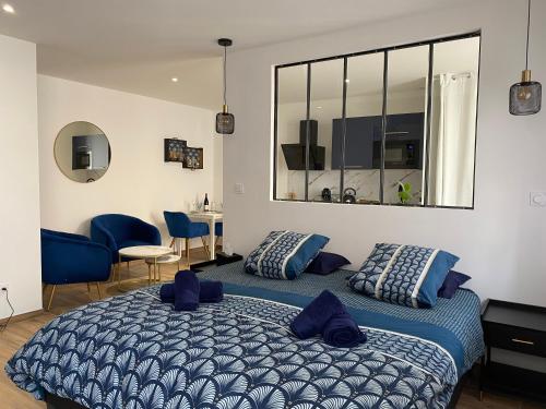 a bedroom with a large bed with blue pillows at Cosy Appart’ & spa - Appartement privatif - baignoire balnéothérapie in Veauche