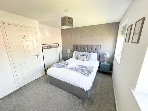 a small bedroom with a bed and a door at Luxury 4 Bed House - Free Parking - Contractors - Relocators in Newcastle upon Tyne