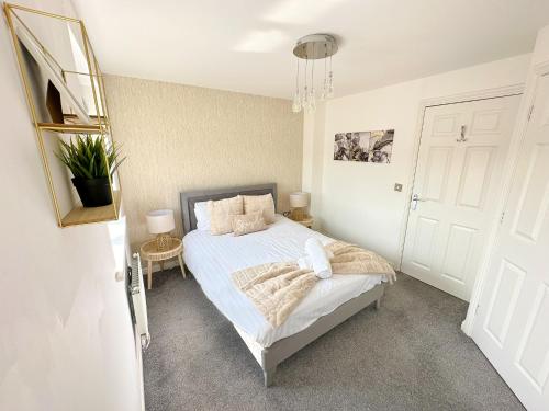 ein Schlafzimmer mit einem Bett mit weißen Laken und Kissen in der Unterkunft Luxury 4 Bed House - Free Parking - Contractors - Relocators in Newcastle upon Tyne