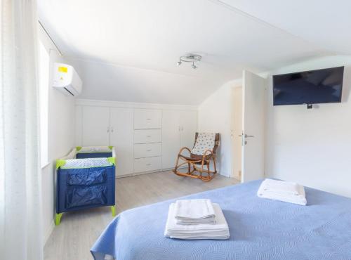 a bedroom with a blue bed and a chair at Holiday Home Riva in Ston