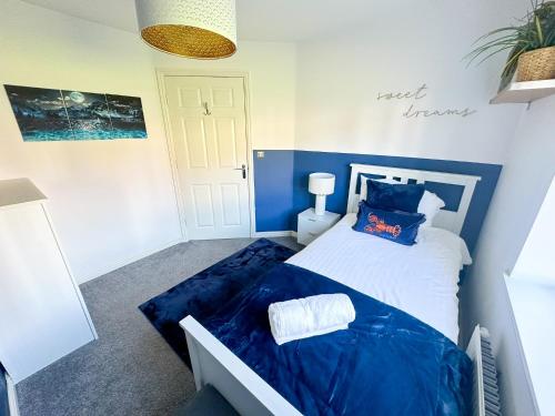 a blue and white bedroom with a bed with blue sheets at Luxury 4 Bed House - Free Parking - Contractors - Relocators in Newcastle upon Tyne