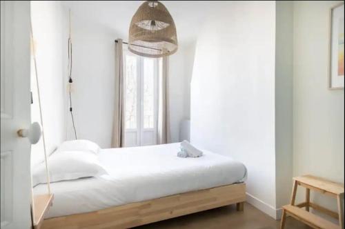 - une chambre avec un lit et une lampe suspendue dans l'établissement T2 Lumineux avec Terrasse proche catalans, à Marseille