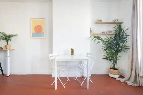 une table et des chaises blanches dans une pièce ornée de plantes dans l'établissement T2 Lumineux avec Terrasse proche catalans, à Marseille