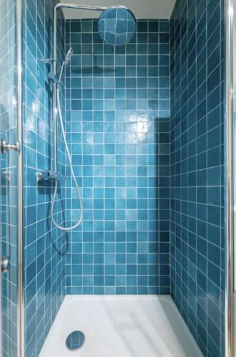 La salle de bains est pourvue de carrelage bleu, d'une douche et d'un lavabo. dans l'établissement T2 Lumineux avec Terrasse proche catalans, à Marseille