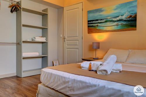 - une chambre avec un lit et des serviettes dans l'établissement Baie Rose avec vue mer - 2 chambres - 3 étoiles - Saint-Leu, à Saint-Leu