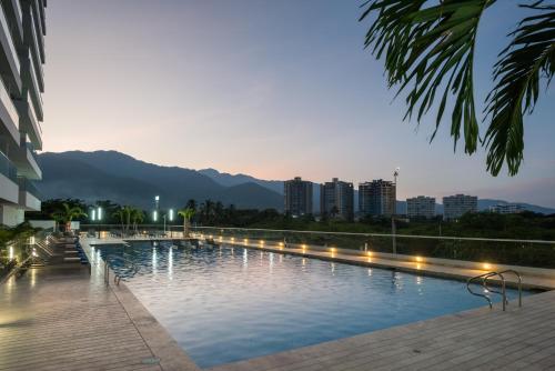 una gran piscina con luces frente a un edificio en Mercure Santa Marta Emile, en Santa Marta