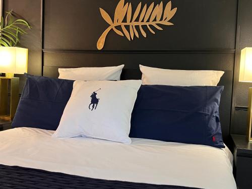 une chambre avec un lit avec des oreillers bleus et blancs dans l'établissement Palais 5min Luxury&Cinema Studio, à Cannes