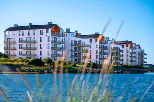 a large apartment building next to a body of water at Apartment Sterntaucher in Olpenitz