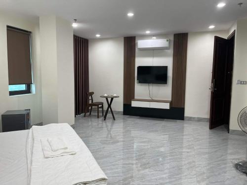 ein Hotelzimmer mit einem Bett und einem Flachbild-TV in der Unterkunft Hotel Việt Hàn in Việt Yên