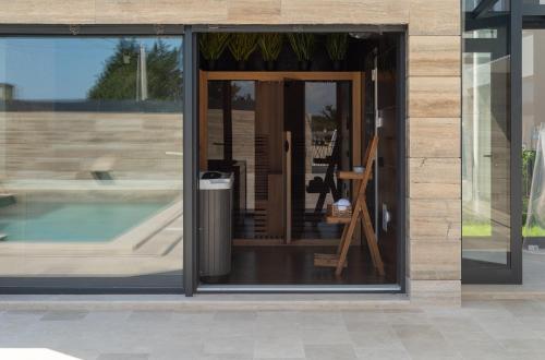 a glass door of a building with a pool at Salt and Stone Villa in Nin