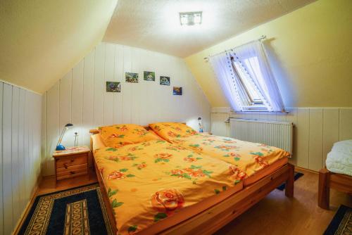 a bedroom with a bed with yellow sheets and a window at Ferienwohnungen im Deichweg in Zingst