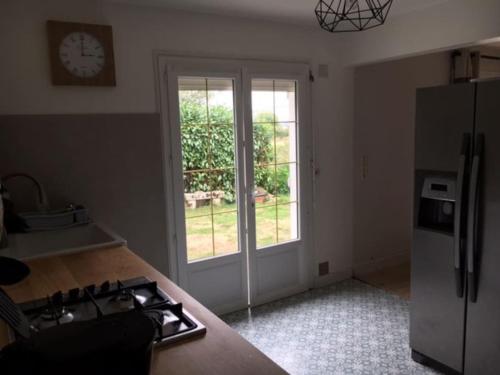 Il comprend une cuisine équipée d'un réfrigérateur et d'une horloge murale. dans l'établissement Cap Mer - Maison 500m plage du Palandrin, à Pénestin