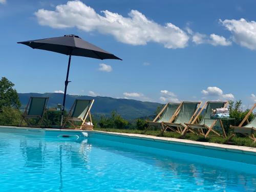 une piscine avec des chaises et un parasol dans l'établissement Maison de la Ferme, à Étang-sur-Arroux