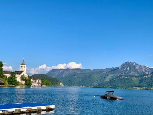 ein Boot in einem See mit Bergen im Hintergrund in der Unterkunft Ferienwohnung Stadlmann in St. Wolfgang