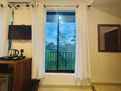 Meegahasewana Bungalow في كورونيغالا: نافذة مع ستائر بيضاء في غرفة مع شرفة