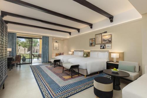 a bedroom with two beds and a living room at Sofitel Al Hamra Beach Resort in Ras al Khaimah