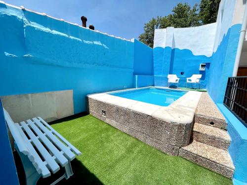 a blue building with a swimming pool and two chairs at Casa Rural Pernales I in Ruidera