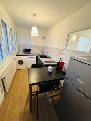 une petite cuisine avec une table et un réfrigérateur dans l'établissement Appartement Chalon, à Chalon-sur-Saône