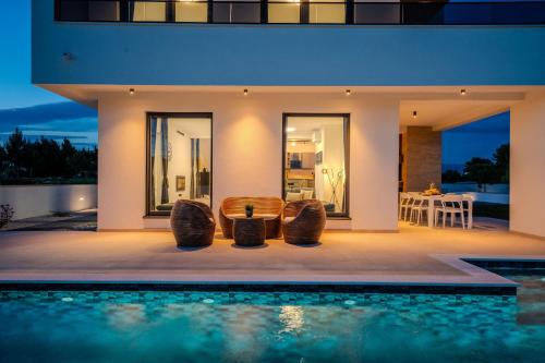 een villa met zwembad 's nachts bij Villa Karlo ZadarVillas in Glavan