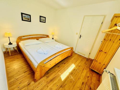 1 dormitorio con cama de madera y suelo de madera en Appartement Rosenwinkel, en Warnemünde