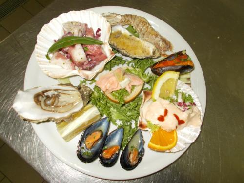 a plate of oysters and seafood on a table at Hotel Maremonti in Vico del Gargano
