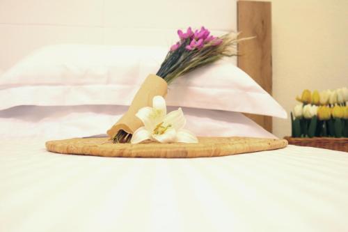 un bouquet de fleurs assises au-dessus d'un lit dans l'établissement Thassion-ikea Jacuzzi private villa, à Astris