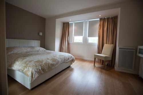 une chambre avec un lit, une chaise et une fenêtre dans l'établissement MAISON 4 CHAMBRES,JARDIN ET TERRASSE, proche mer,casino et place Morny, à Deauville