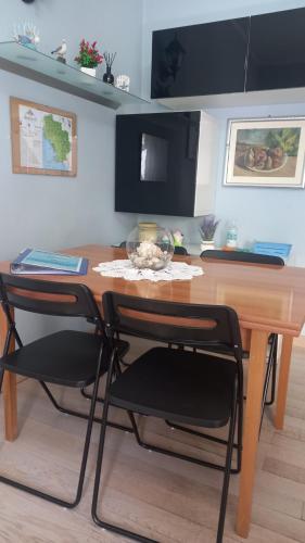 a kitchen with a wooden table and two chairs at La Casa di Barbanella in Grosseto