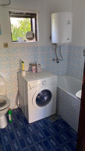 een badkamer met een wasmachine en een bad bij Julija 