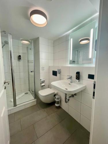 a bathroom with a toilet and a sink and a shower at Hopfenhotel am Adenauerufer in Bamberg
