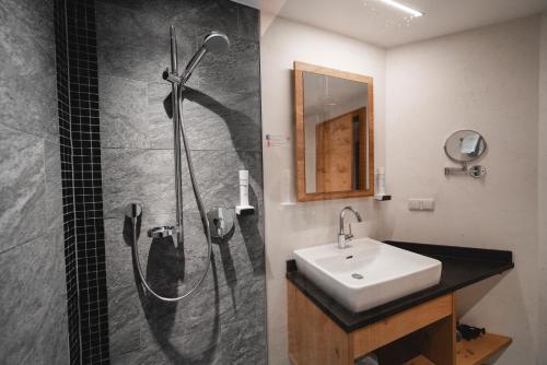 a bathroom with a shower and a sink at Genusshotel Fichtenhof in Grossarl