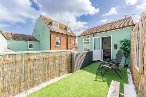 a small backyard with a chair and a fence at The Cottage at Logan Lodge in Great Yarmouth